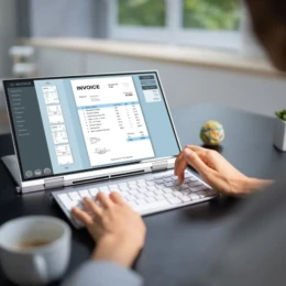 Un homme est en train de revoir une facture de son entreprise d'e-commerce grâce à son application de comptabilité shopify