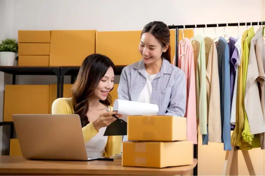 2 femmes sont en train de travailler pour leur marque de e-commerce au milieu des commandes